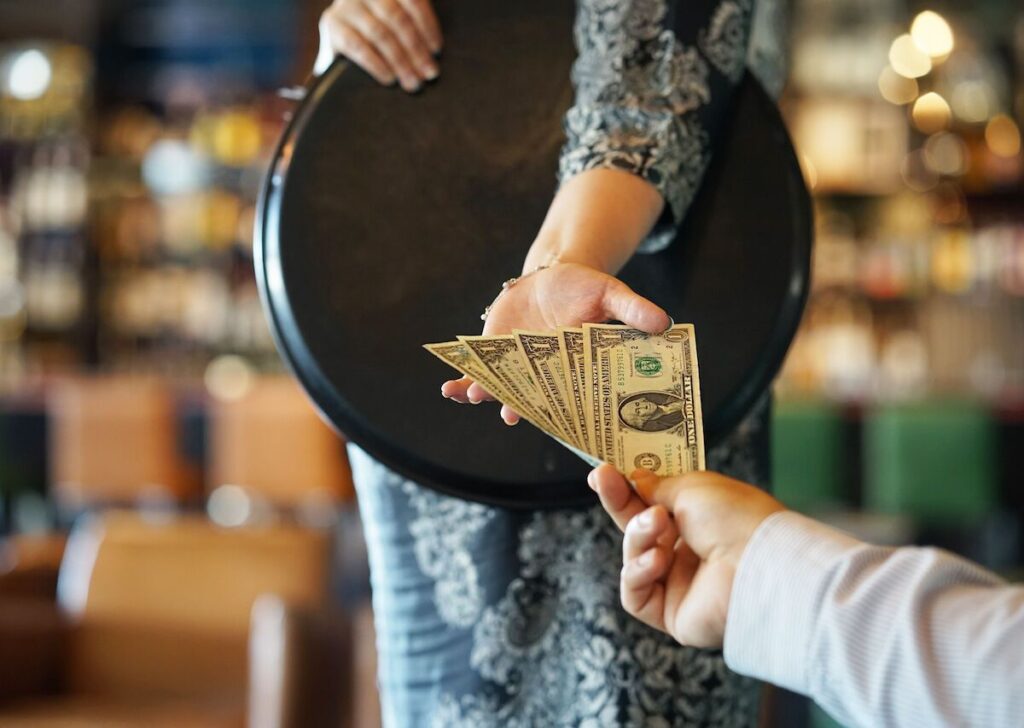 Tipping in Mexico: A customer's hand extending a tip to a wait staff member in a villa rental