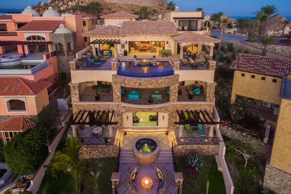 Casa Piedra Pedregal aerial exterior at twilight with a pool and garden fire bowl — Los Cabos, Mexico