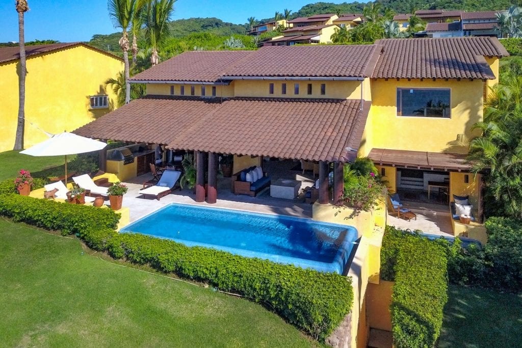 Four Seasons Twin Villas aerial view of a yellow residence, pool, and lawn — Punta Mita Nayarit, Mexico