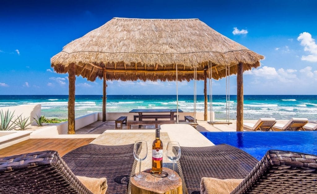 Villa Sofia beer on the table under the palapa at the pool — Tulum, Mexico