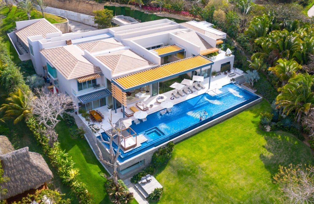 Casa Brisa angled aerial view over the pool, lawn, and villa roofs — Punta Mita Nayarit, Mexico