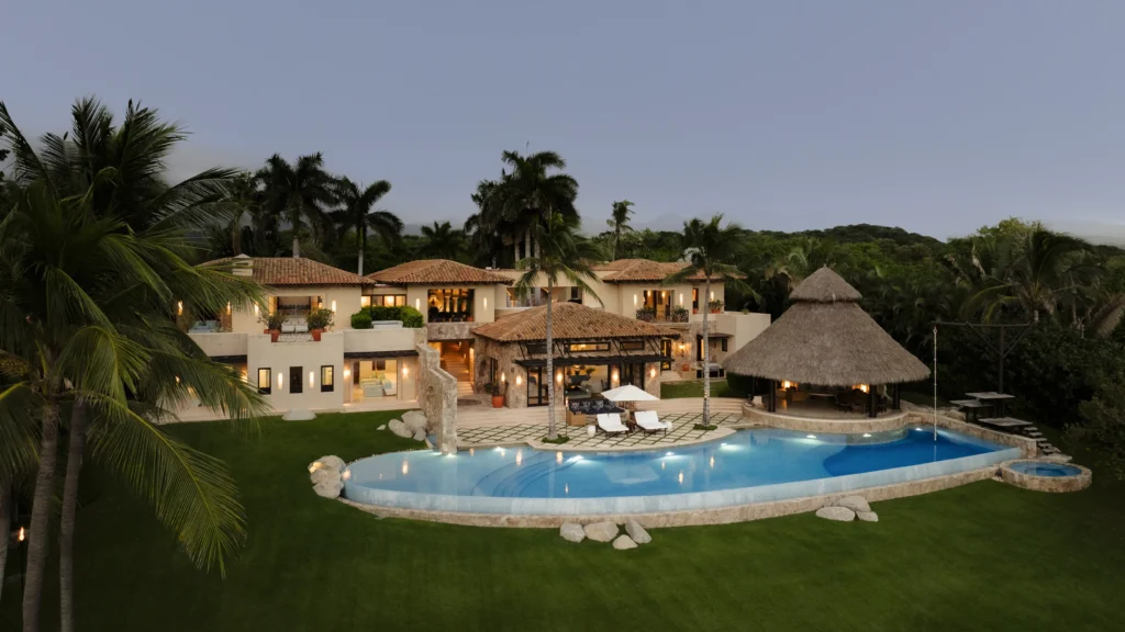 Casa La Vida Dulce villa, swimming pool, lawn, and palapa at dusk — Punta Mita Nayarit, Mexico
