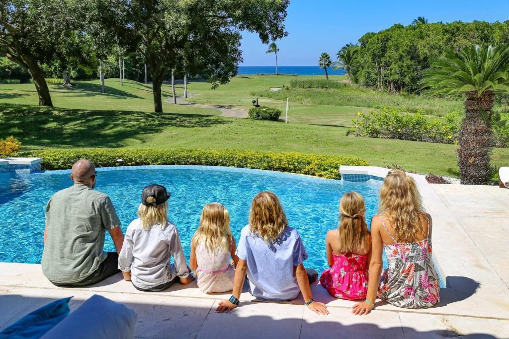 Family enjoying time by the pool overlooking the golf course at a Las Palmas Punta Mita villa
