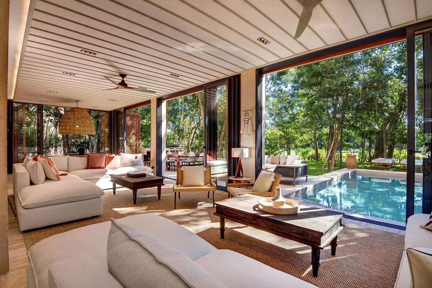 Palm Villa Experience open living room with white sofas beside the pool — Playa del Carmen, Mexico