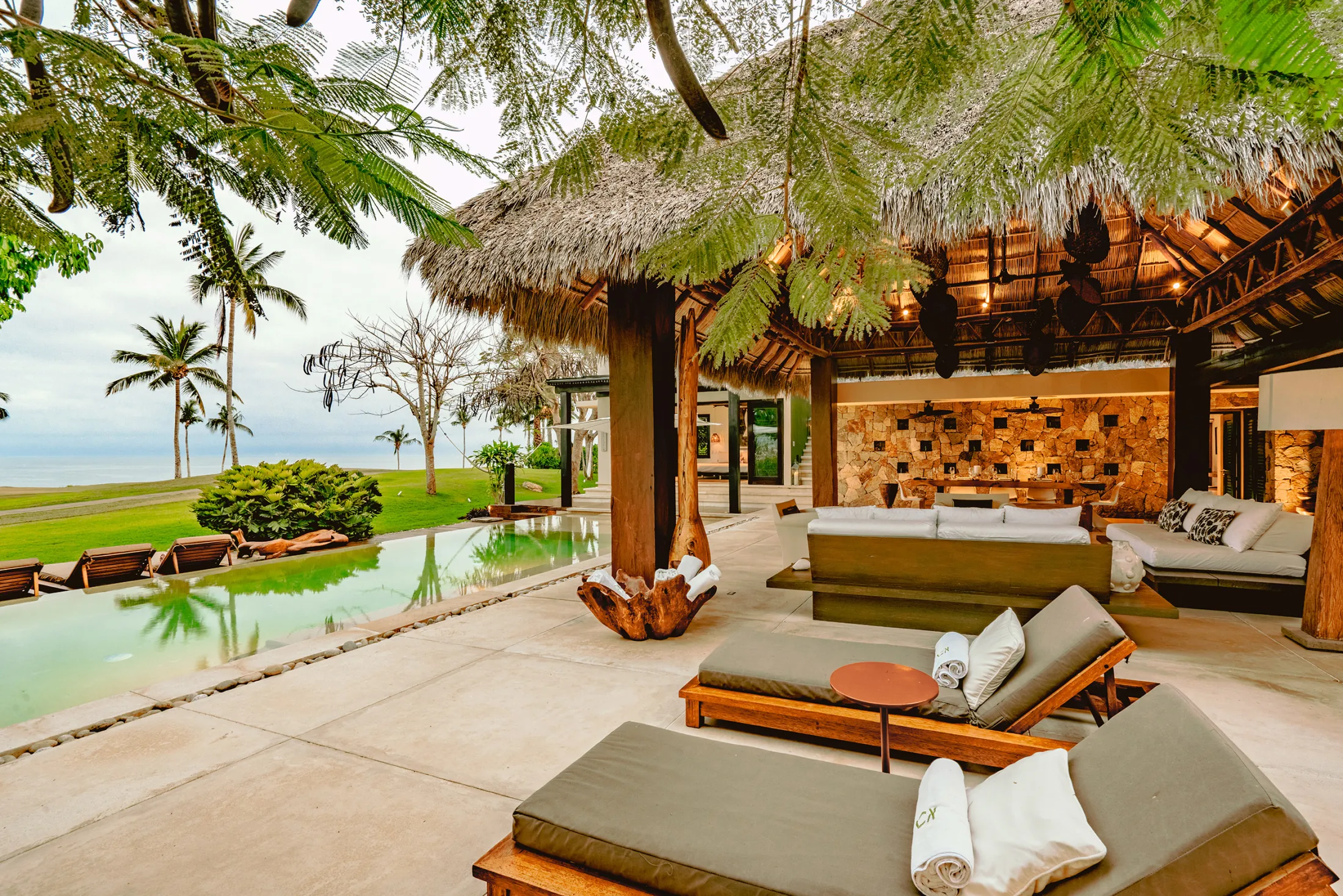Casa Kalika palapa lounge and daybeds beside the green pool — Punta Mita Nayarit, Mexico