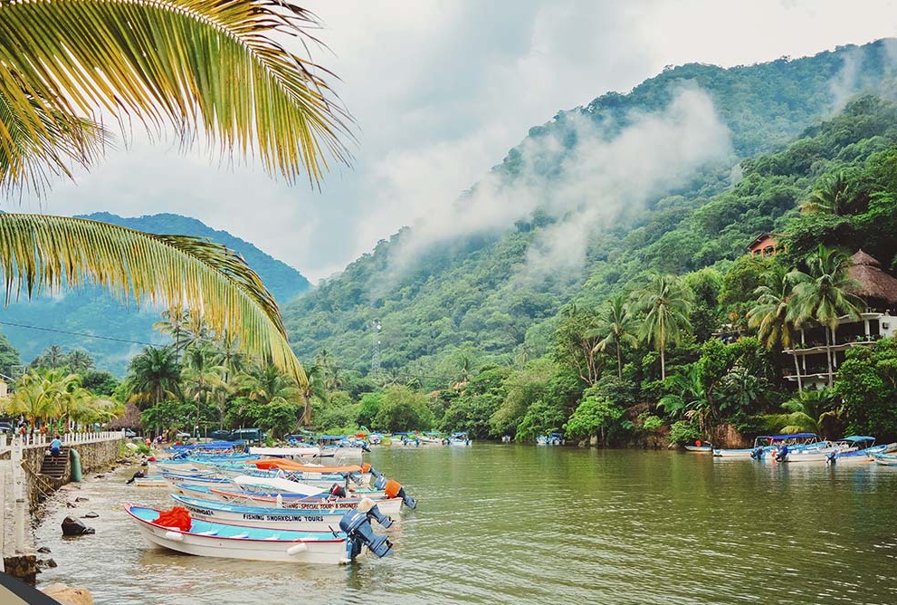 Mismaloya Bay with anchored boats and the majestic Sierra Madre mountains looming in the background.