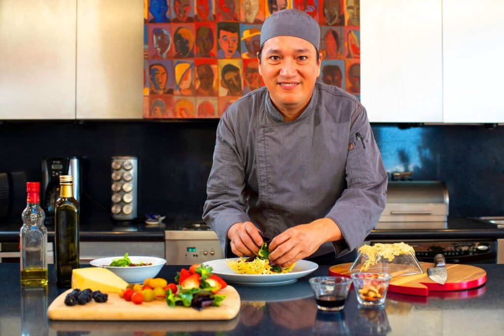 Chef standing in the kitchen, preparing food in a villa rental with chef service.