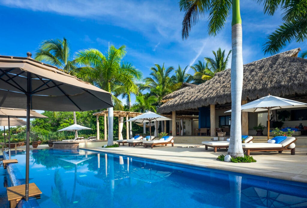 Casa La Caleta long pool lined with loungers and shade umbrellas — Punta Mita Nayarit, Mexico