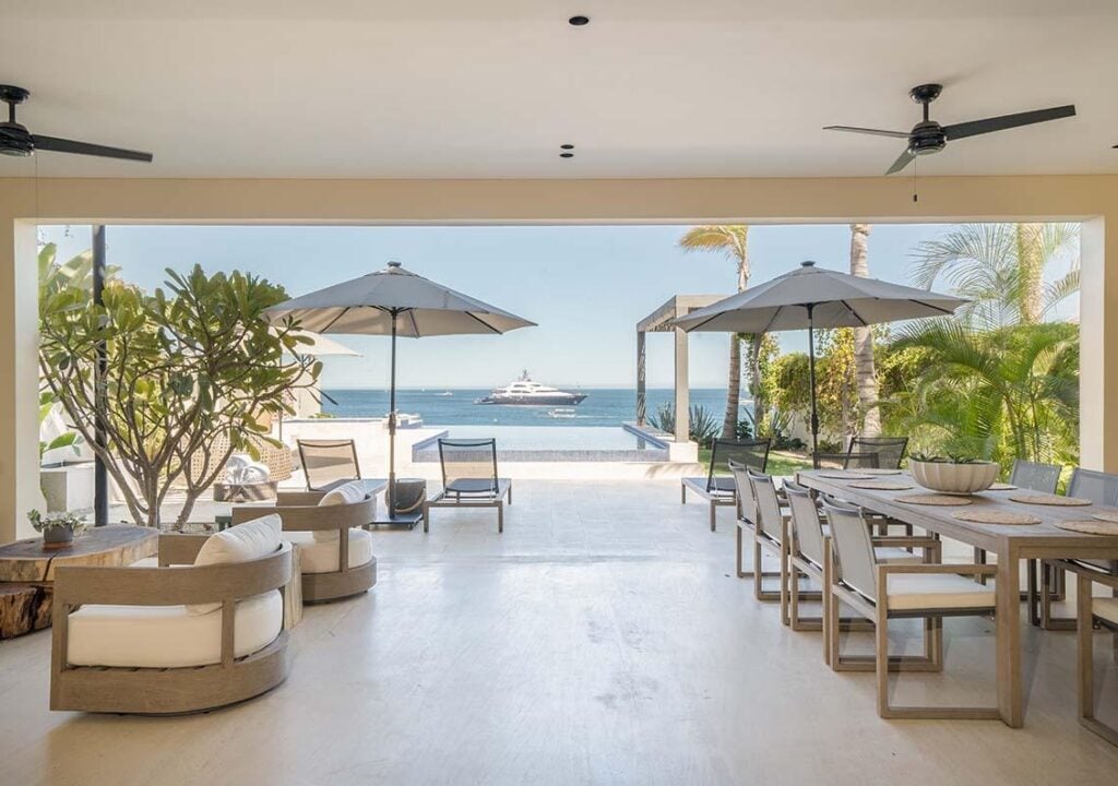 Villa Marena covered terrace with dining table, lounge seating and ocean view — Los Cabos, Mexico