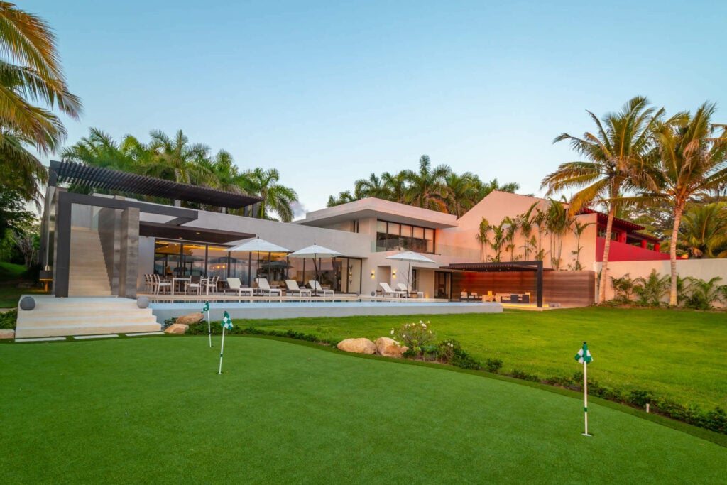 Estate Afrique putting green with two flags and the villa beyond — Punta Mita Nayarit, Mexico