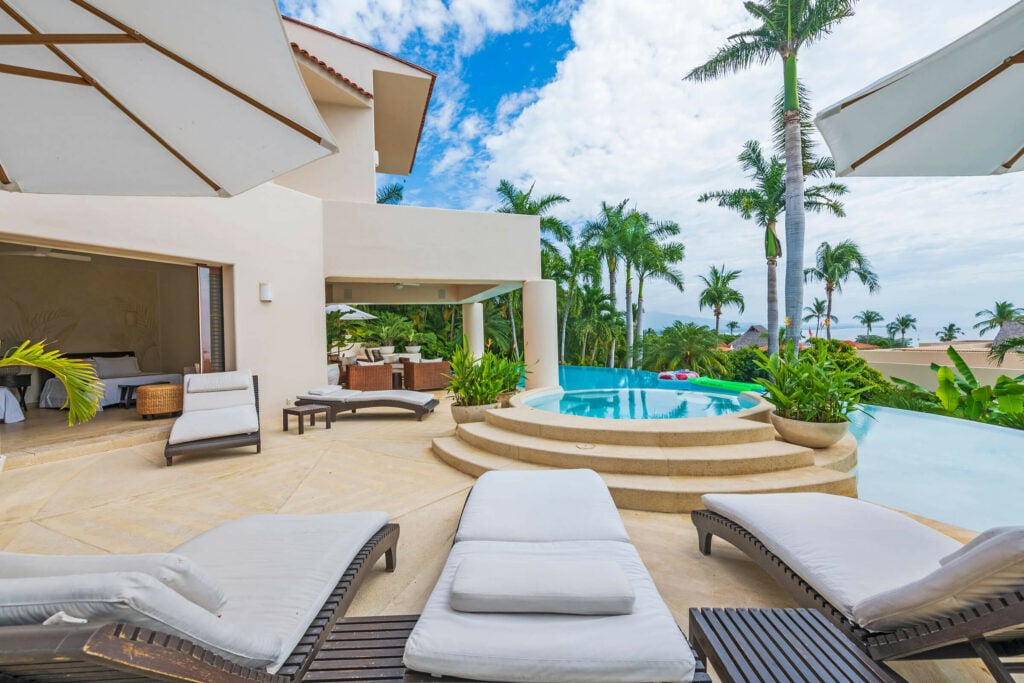 Villa Alamanda poolside loungers with the villa and palms behind — Punta Mita Nayarit, Mexico