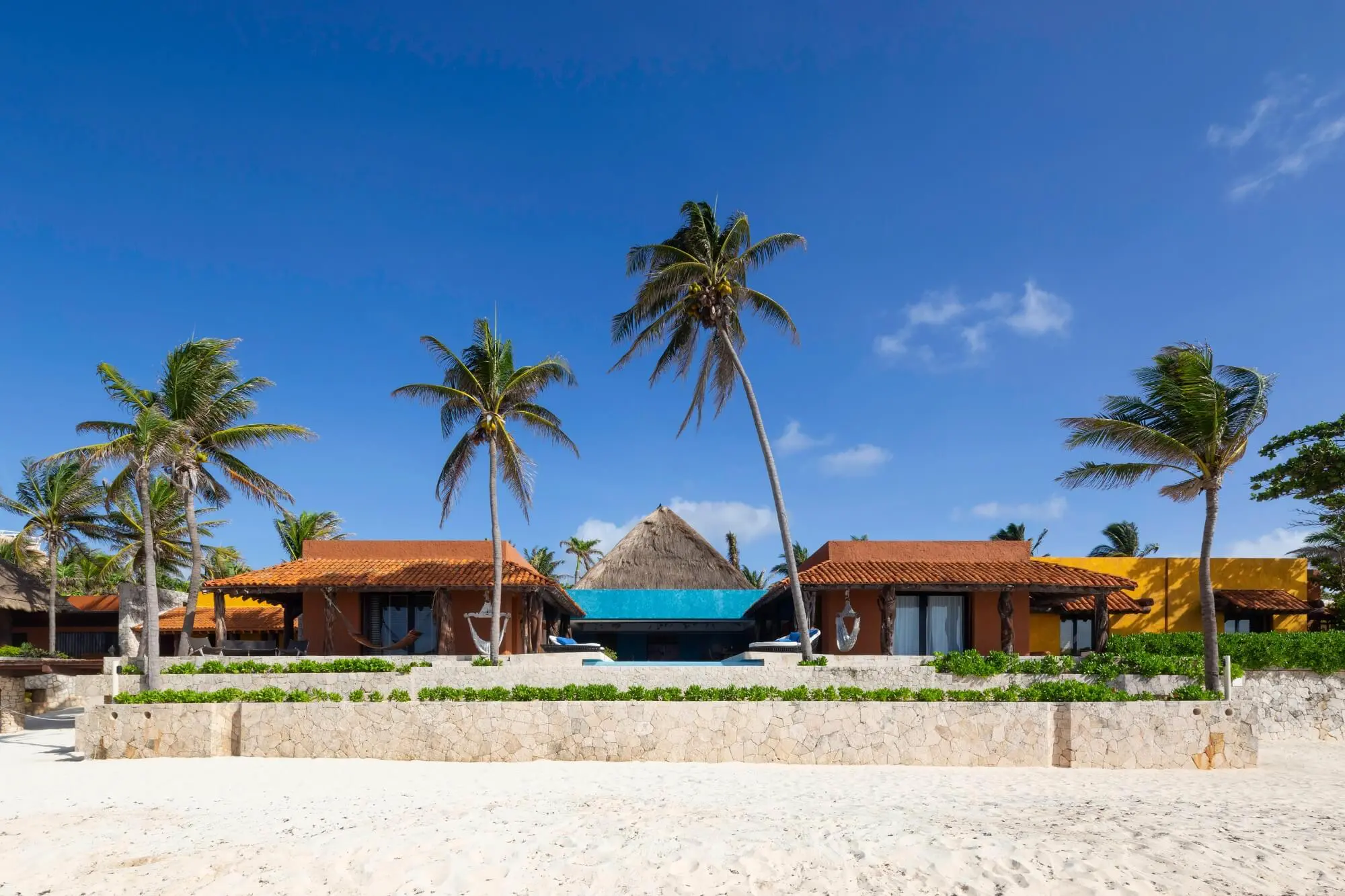 Casa Corazon beachfront exterior with palm trees and white sand — Playa del Carmen, Mexico