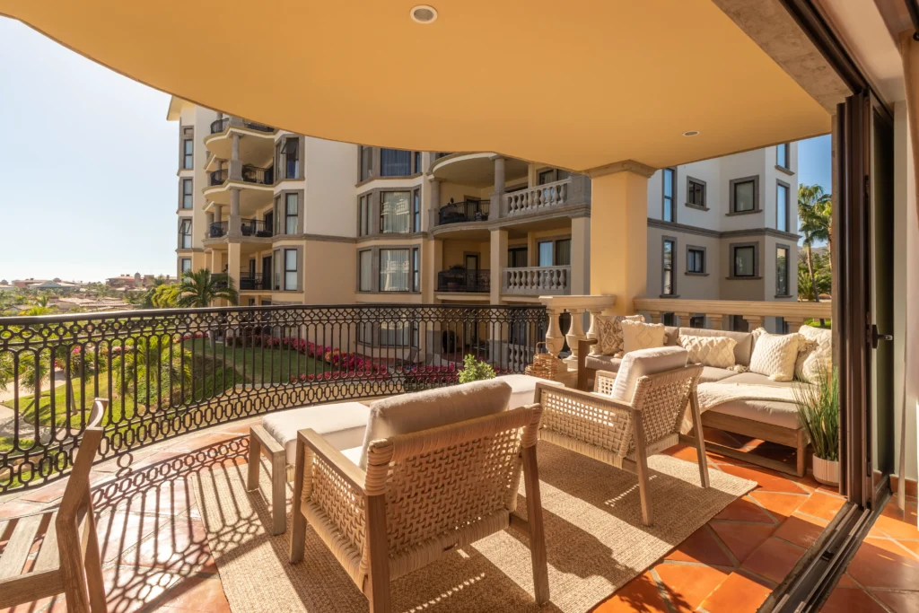 Casa Buena Onda Puerta del Sol B201 terrace lounge with woven seating and neighboring building view — Los Cabos, Mexico
