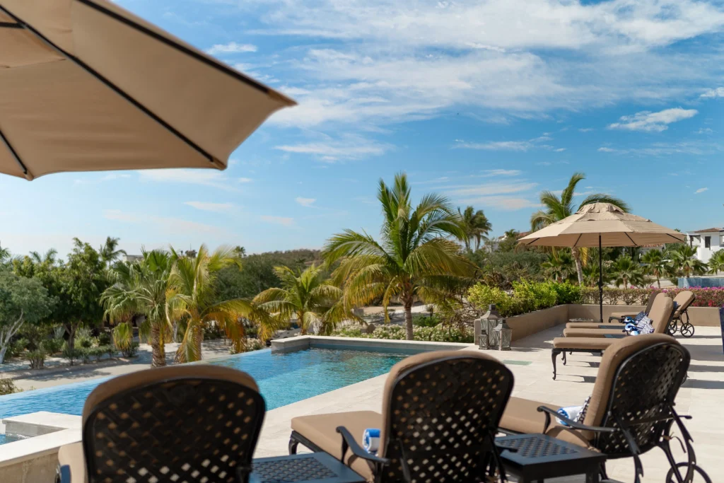 Luxury outdoor pool area with lounge chairs and umbrellas. Surrounded by lush greenery in Mexico, a haven for relaxation.