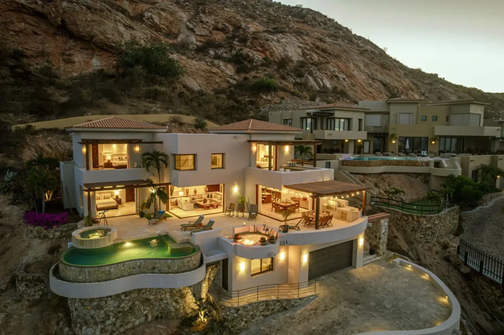 Casa Rayrae multilevel villa with lit terraces, pool and round spa beneath rocky hill — Los Cabos, Mexico