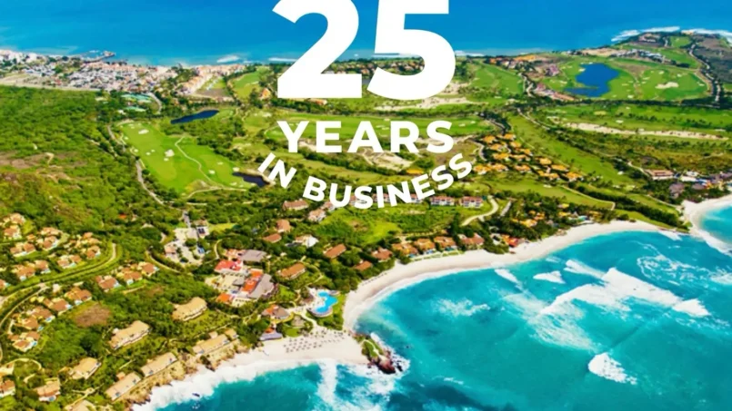 Aerial view of Punta Mita’s coastline with lush greenery, golf courses, and luxury homes, celebrating 25 years in business. The ocean waves crash against the shore, showcasing the stunning natural beauty of the destination.