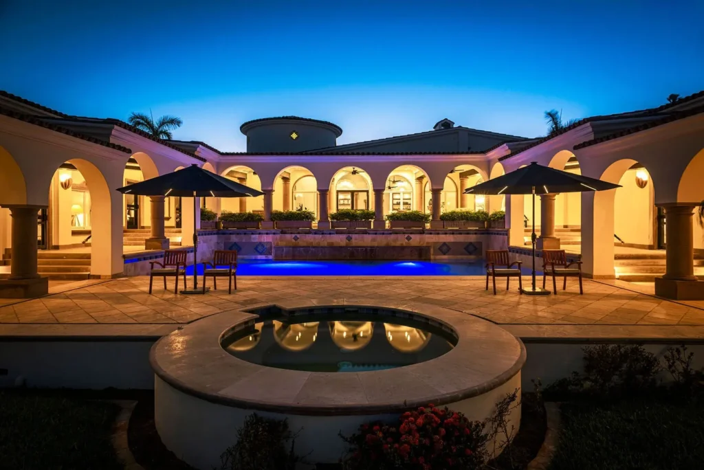 Villa Tortuga Punta Bella courtyard at dusk with round fountain and bar seating — Los Cabos, Mexico