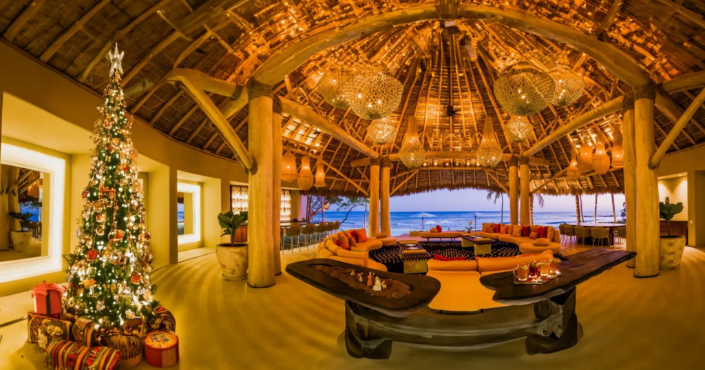 Luxury villa in Punta Mita: open-air lounge, thatched roof, ocean view, festive tree with lights and gifts.