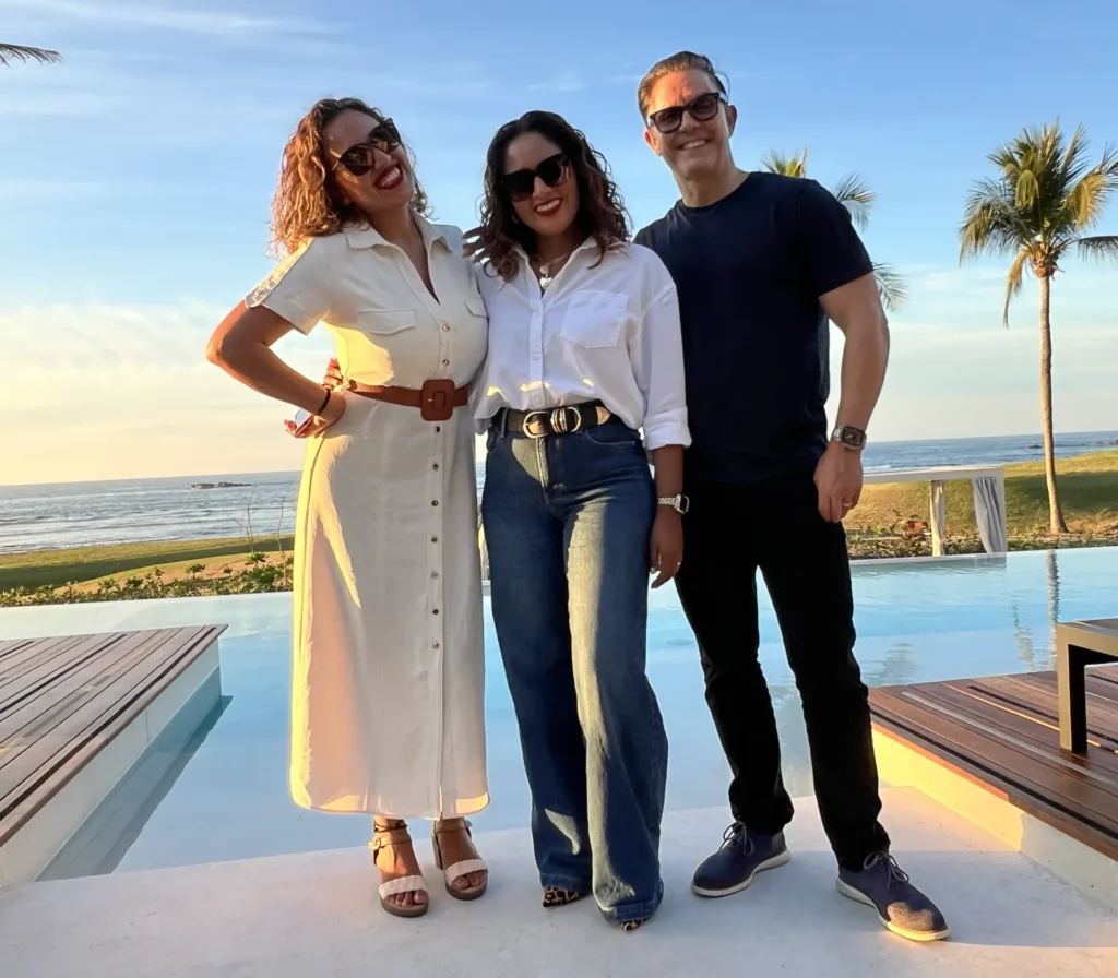 Villa Experience Team members Rocio, Albriet, and Liver smile by the pool at Punta Pacifico Estate’s open house, showcasing the villa’s luxury amenities and ocean-view setting in Punta Mita.