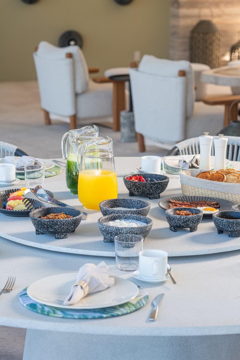 Table set for breakfast with pastries, fruit, and cereals at luxury Punta Pacifico vacation rental in Punta Mita.