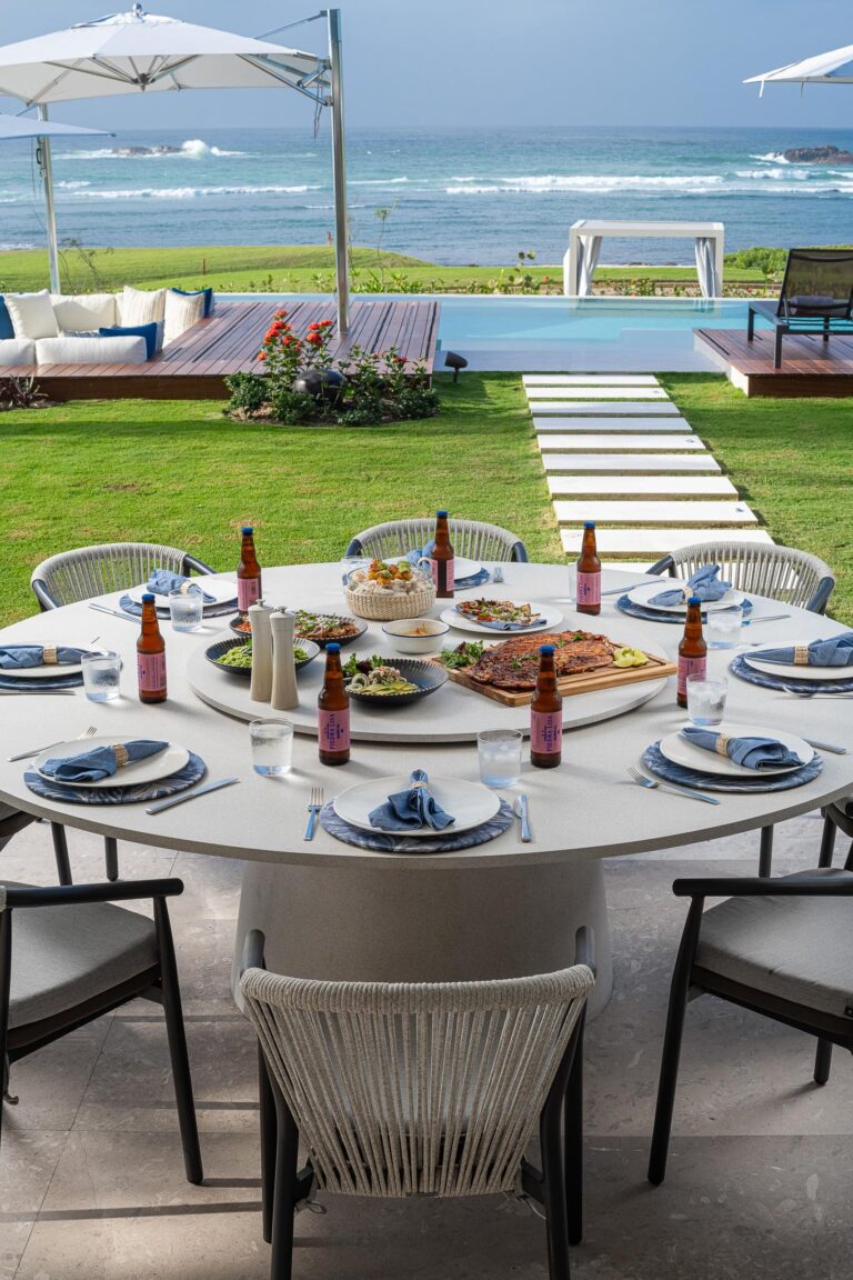 Dining table at Punta Pacifico, Punta Mita, with ocean view; set with pizzas, salads, and beer.