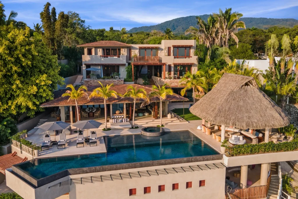 Casa Maka aerial of the pool, thatched pavilion and buildings below green hills — Punta Mita Nayarit, Mexico