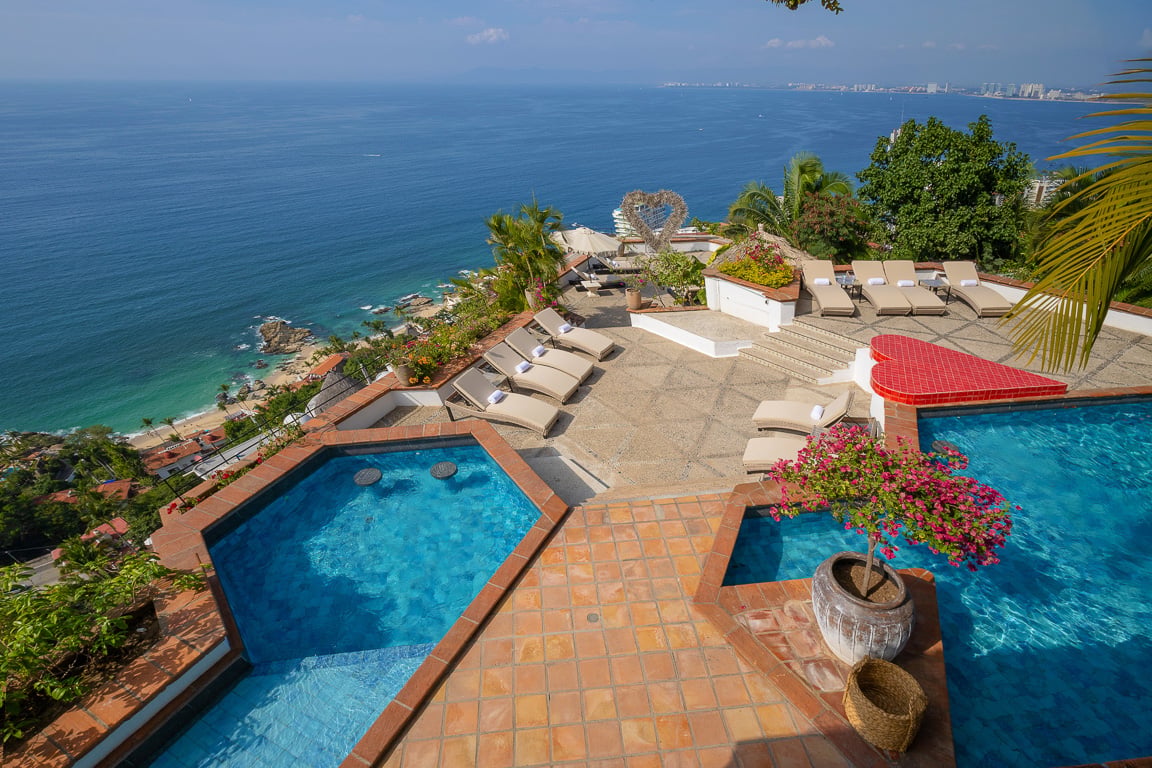 Hacienda Las Flores two pools on the terracotta deck with a red float and loungers — Puerto Vallarta, Mexico