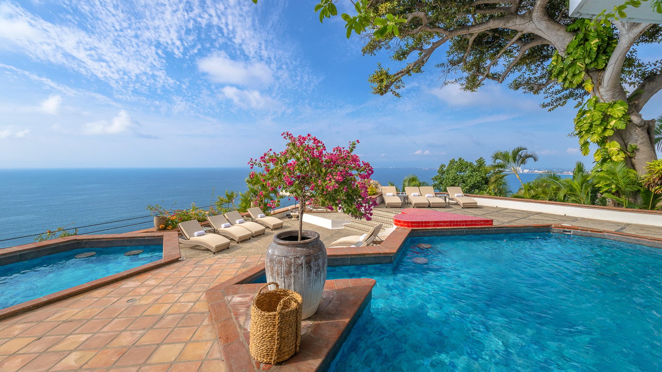 Hacienda Las Flores a flowering shrub in a grey urn beside the pool and its red float — Puerto Vallarta, Mexico