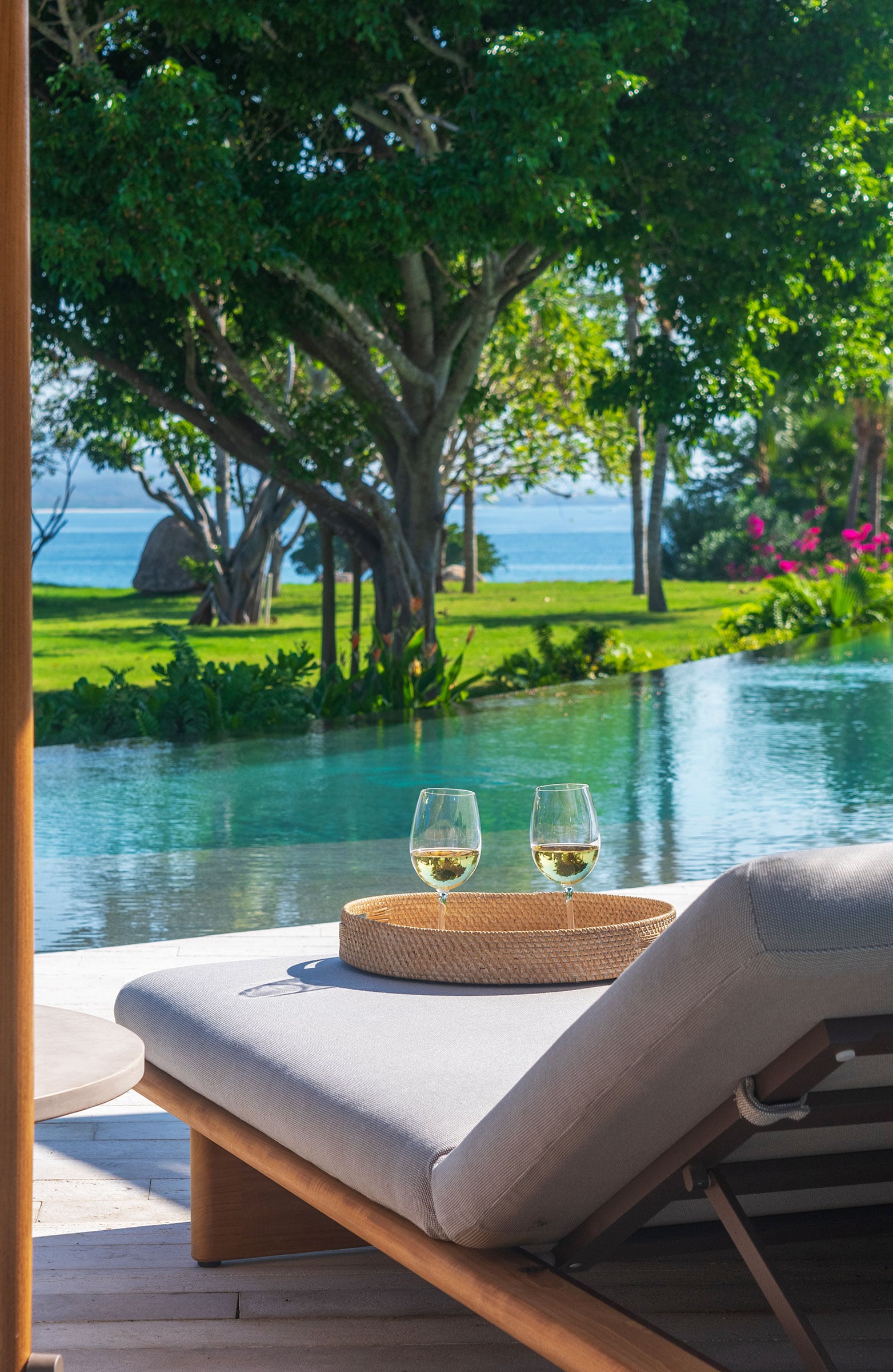 Casa Balena two glasses of white wine on a tray beside a lounger at the pool — Punta Mita, Mexico