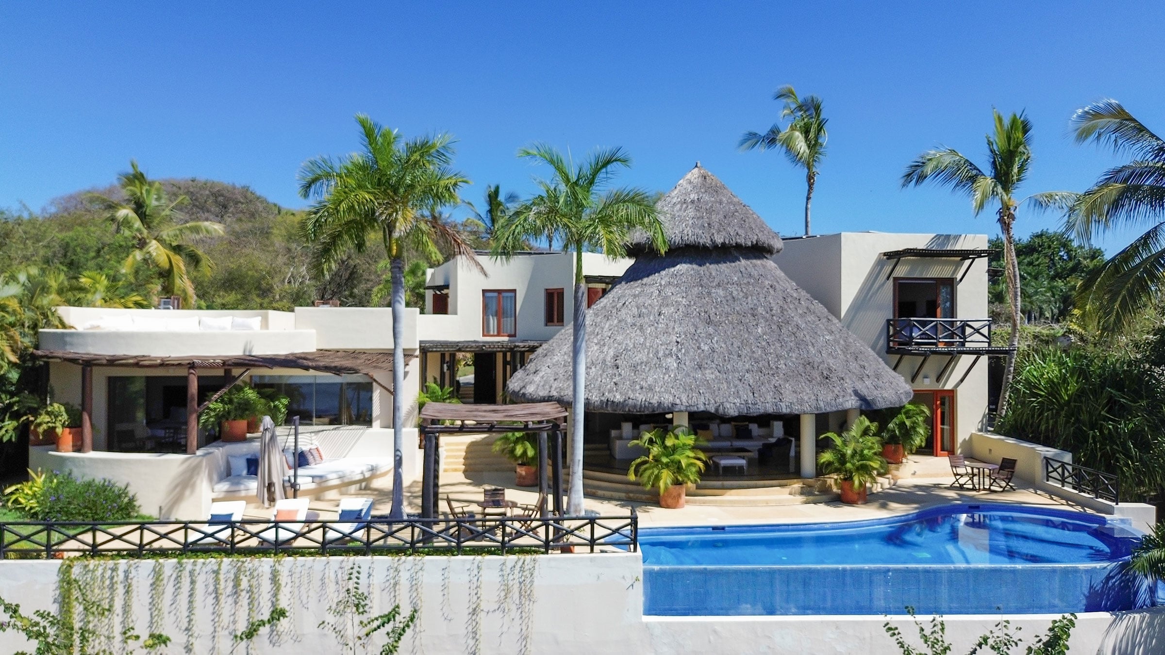 Casa Caracol the white house and its conical palapa above the blue pool — Punta Mita, Mexico