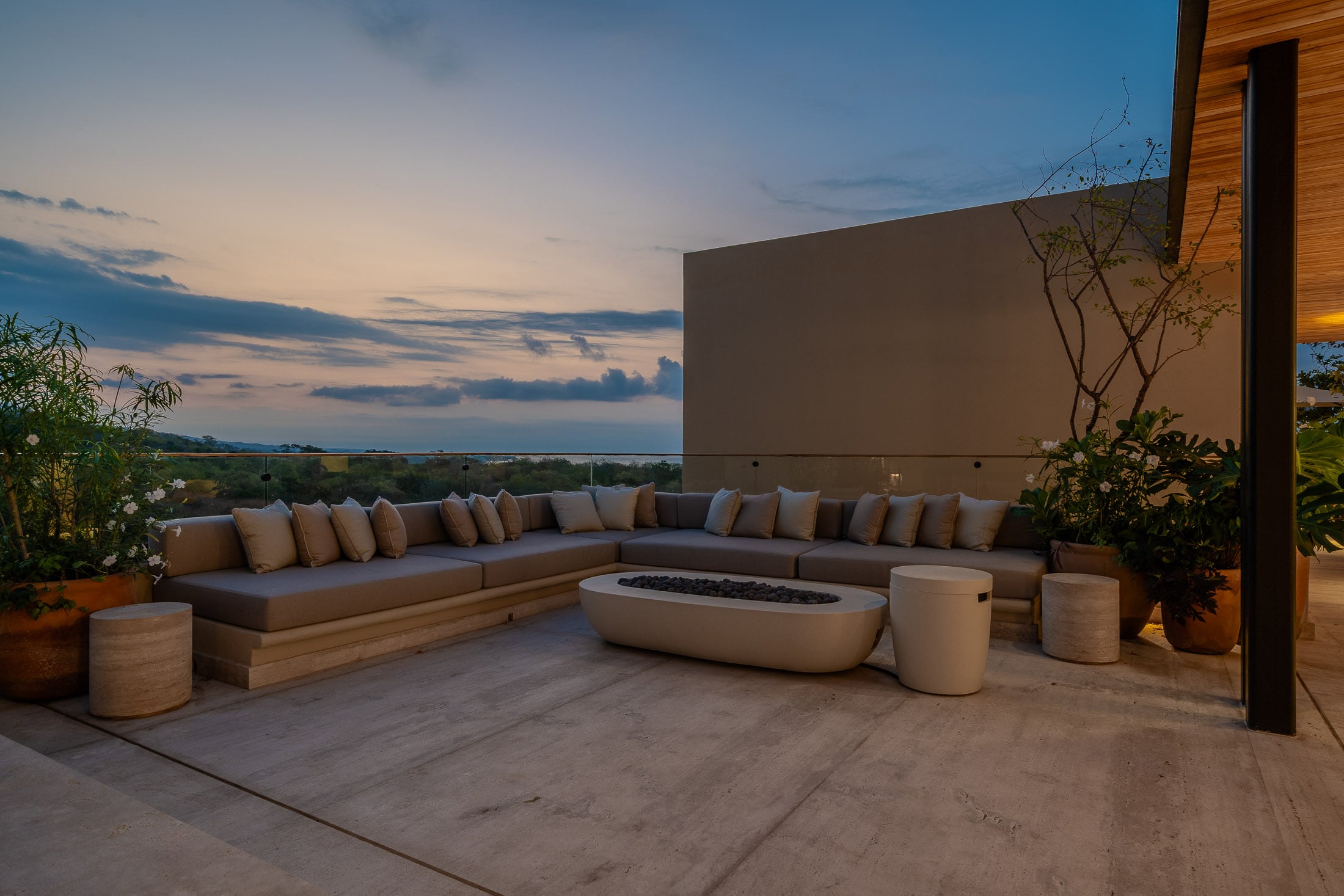 Casa Tuki a long L-shaped bench around the stone fire bowl at sunset — Punta Mita, Mexico