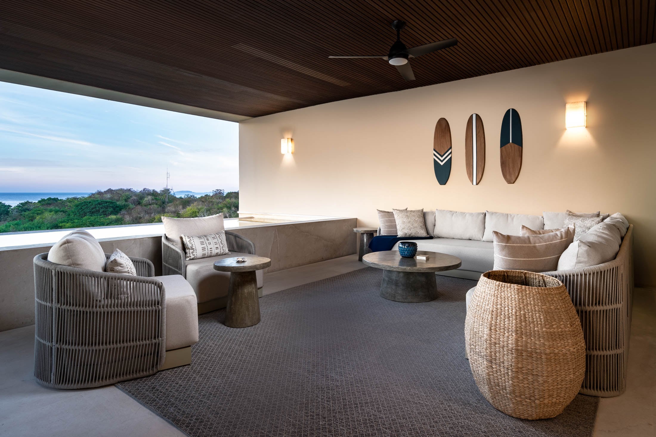 Condo Amor y Surf three decorative surfboards above the terrace sofa and woven basket — Punta Mita, Mexico