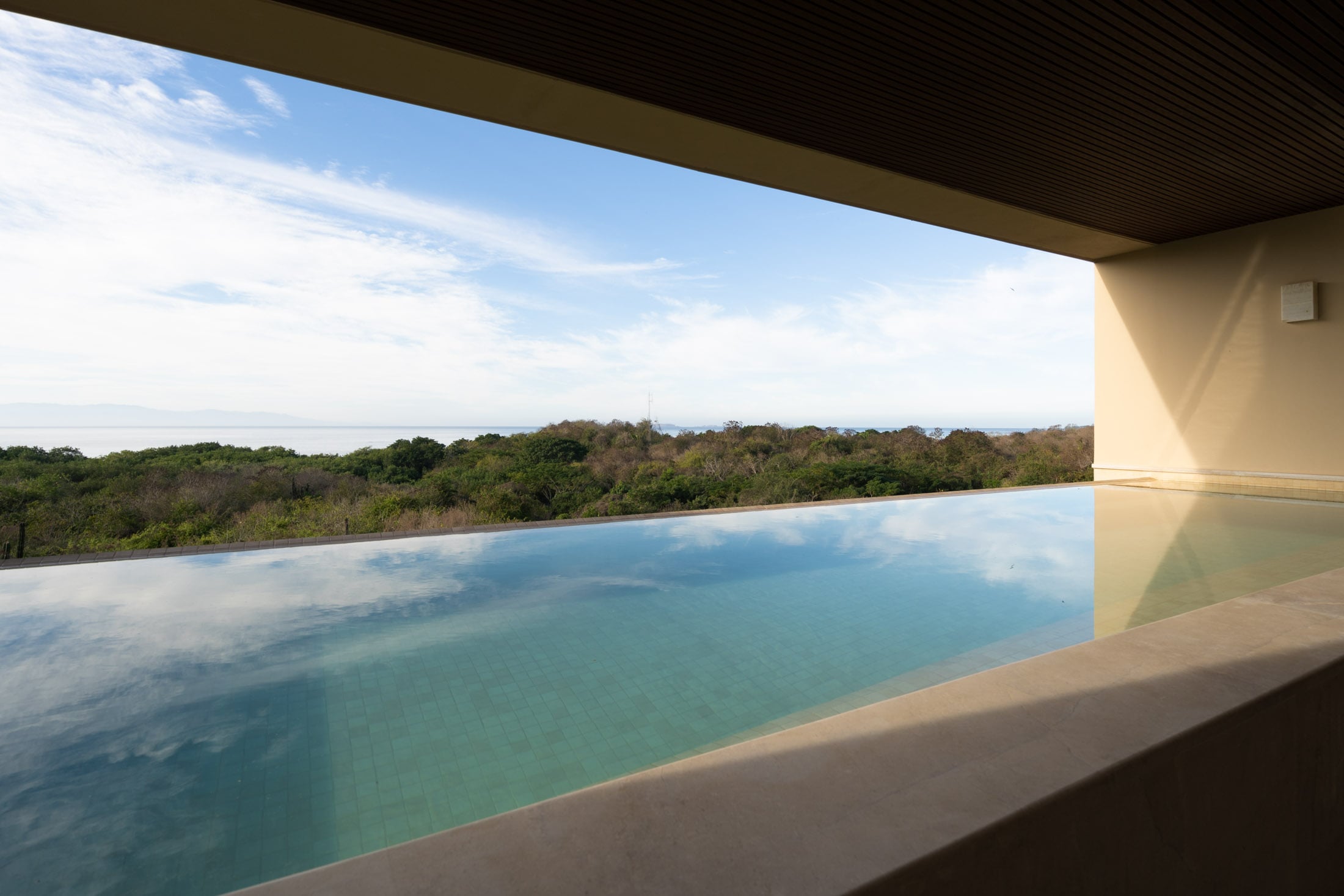 Condo Amor y Surf the long pool under the timber soffit above the forest — Punta Mita, Mexico