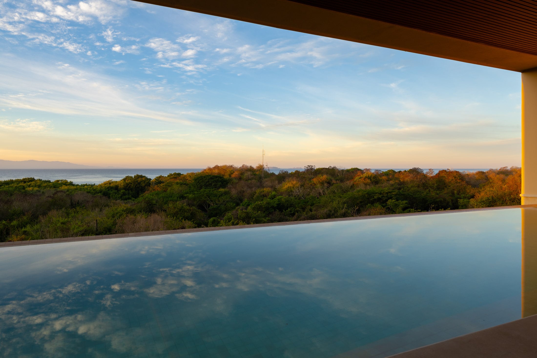 Condo Amor y Surf the infinity pool level with the treetops at sunrise — Punta Mita, Mexico