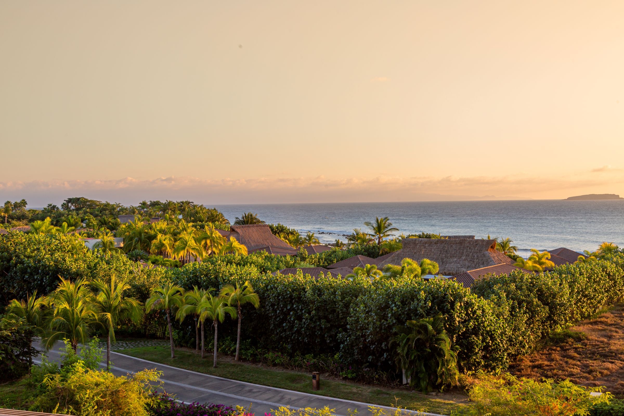 Condo Haramara palms and thatched roofs below the terrace with the sea beyond — Punta Mita, Mexico