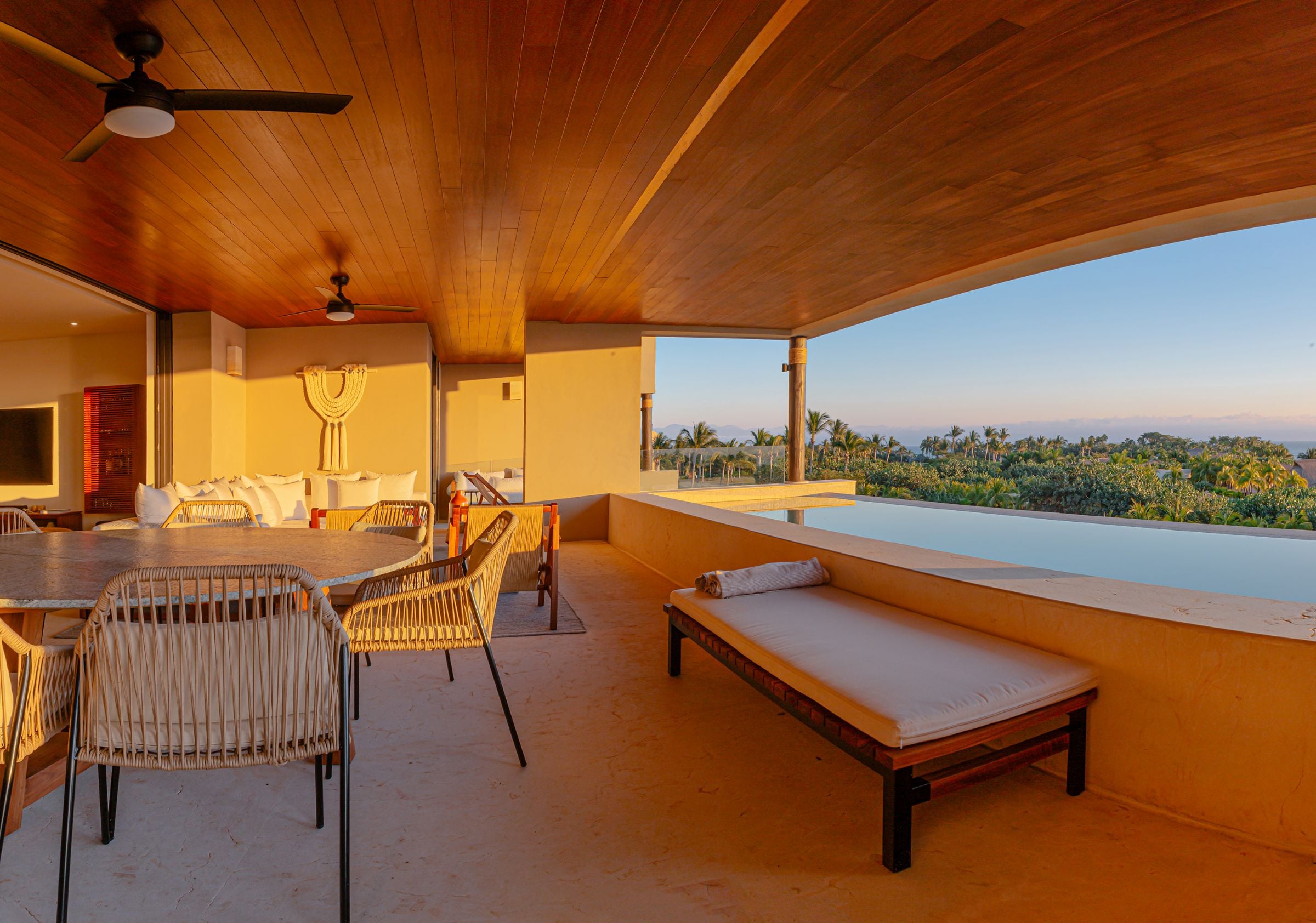 Condo Haramara a cushioned bench beside the long terrace pool at sunset — Punta Mita, Mexico