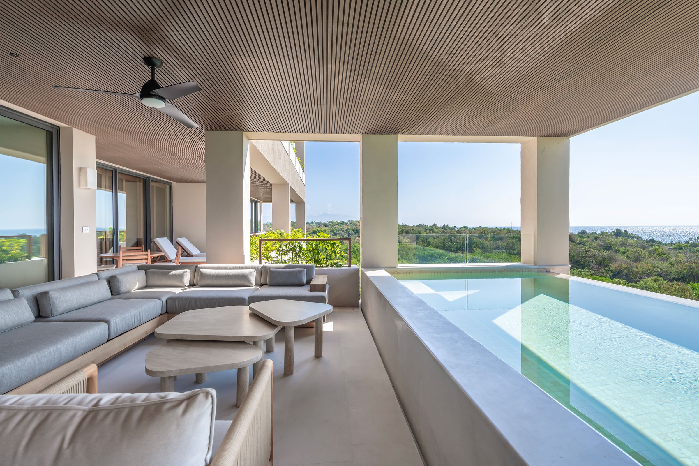 Condo Raya terrace sofas and low tables running the length of the pool — Punta Mita, Mexico