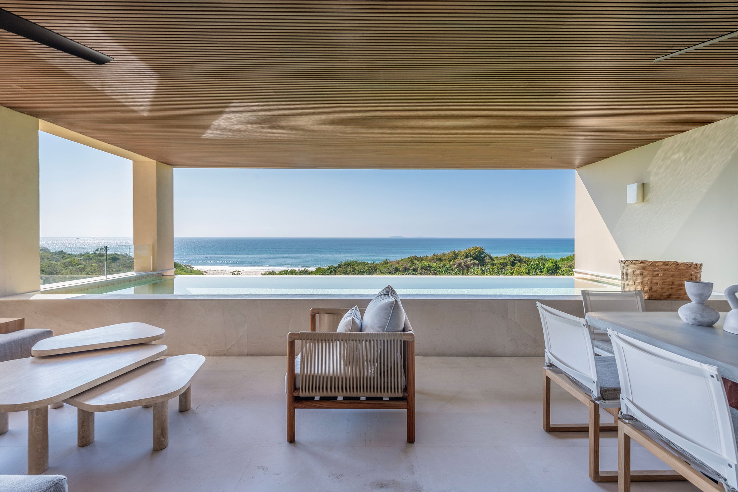 Condo Raya a low wooden bench and armchair on the terrace beside the pool — Punta Mita, Mexico