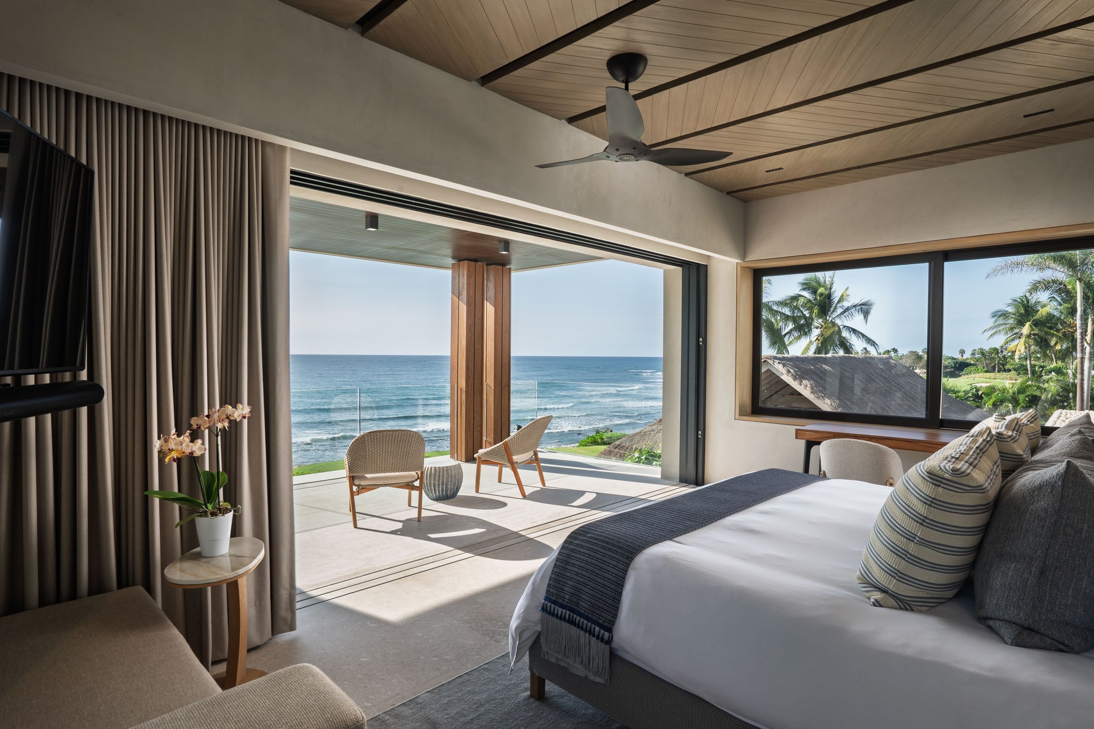 Estate Elementos white flower on a bedside table by open terrace doors — Punta Mita Nayarit, Mexico