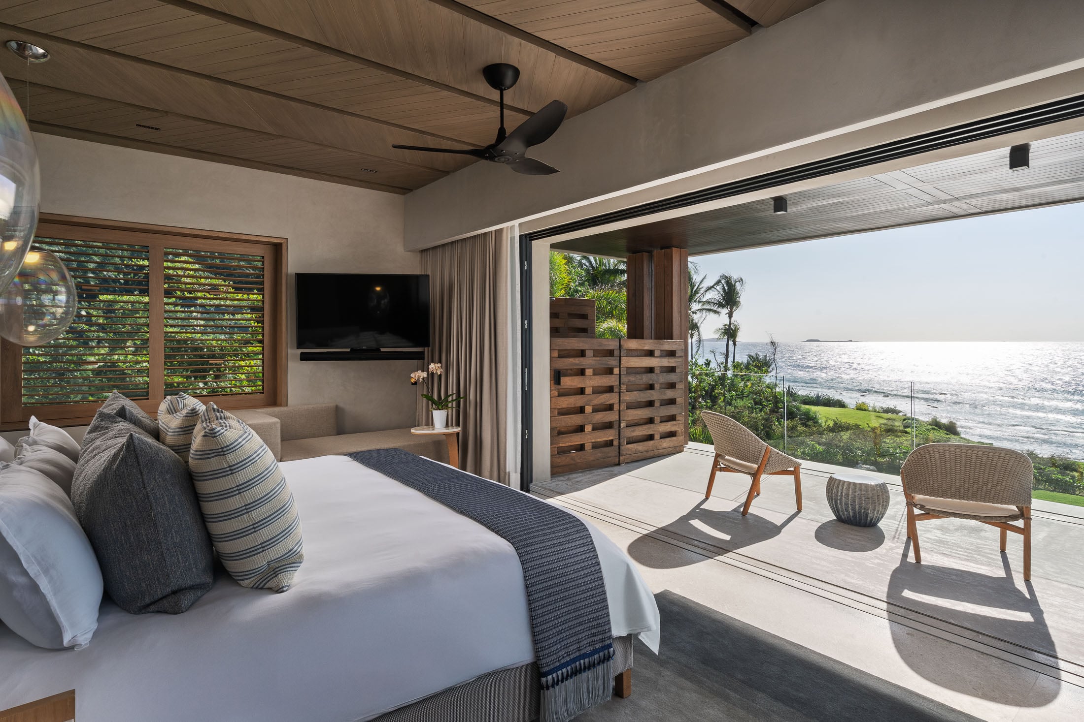Estate Elementos bedroom opening to a terrace with two chairs above the sea — Punta Mita Nayarit, Mexico