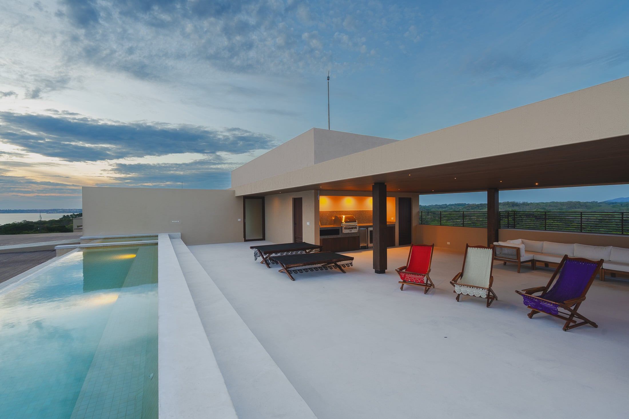 Penthouse ArenaMar red, white and purple deck chairs along the rooftop pool — Punta Mita, Mexico