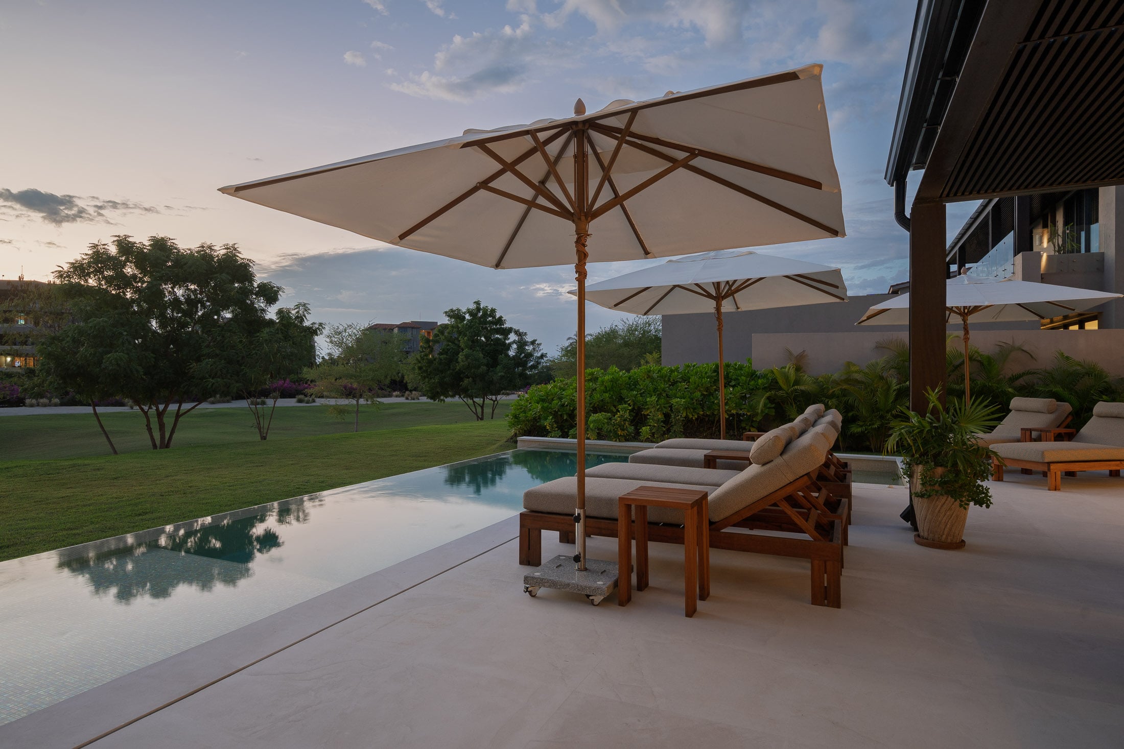 Villa Amada an umbrella and lounger reflected in the pool at dusk — Punta Mita, Mexico