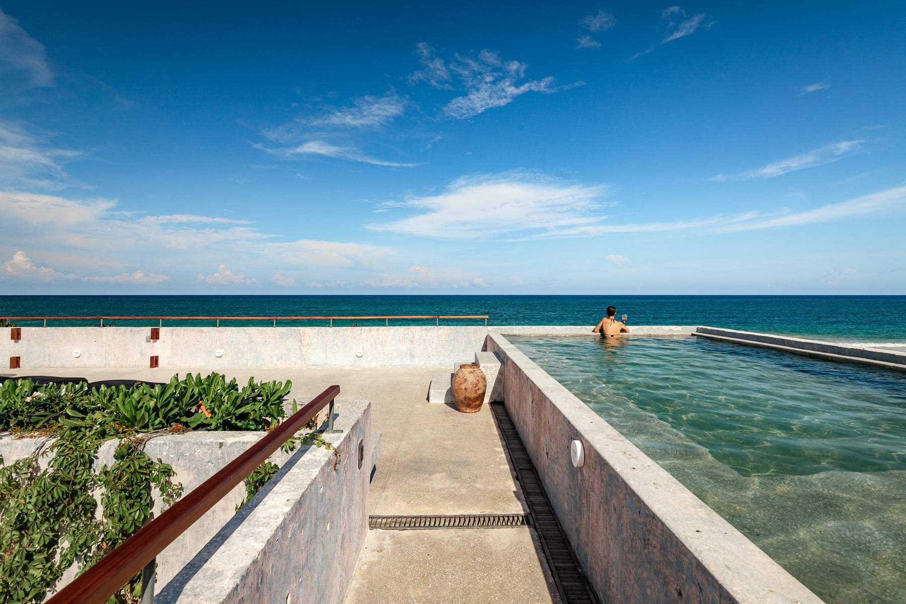 Villa Amistad one person in the water at the far edge of the pool, ocean beyond — Punta Mita, Mexico