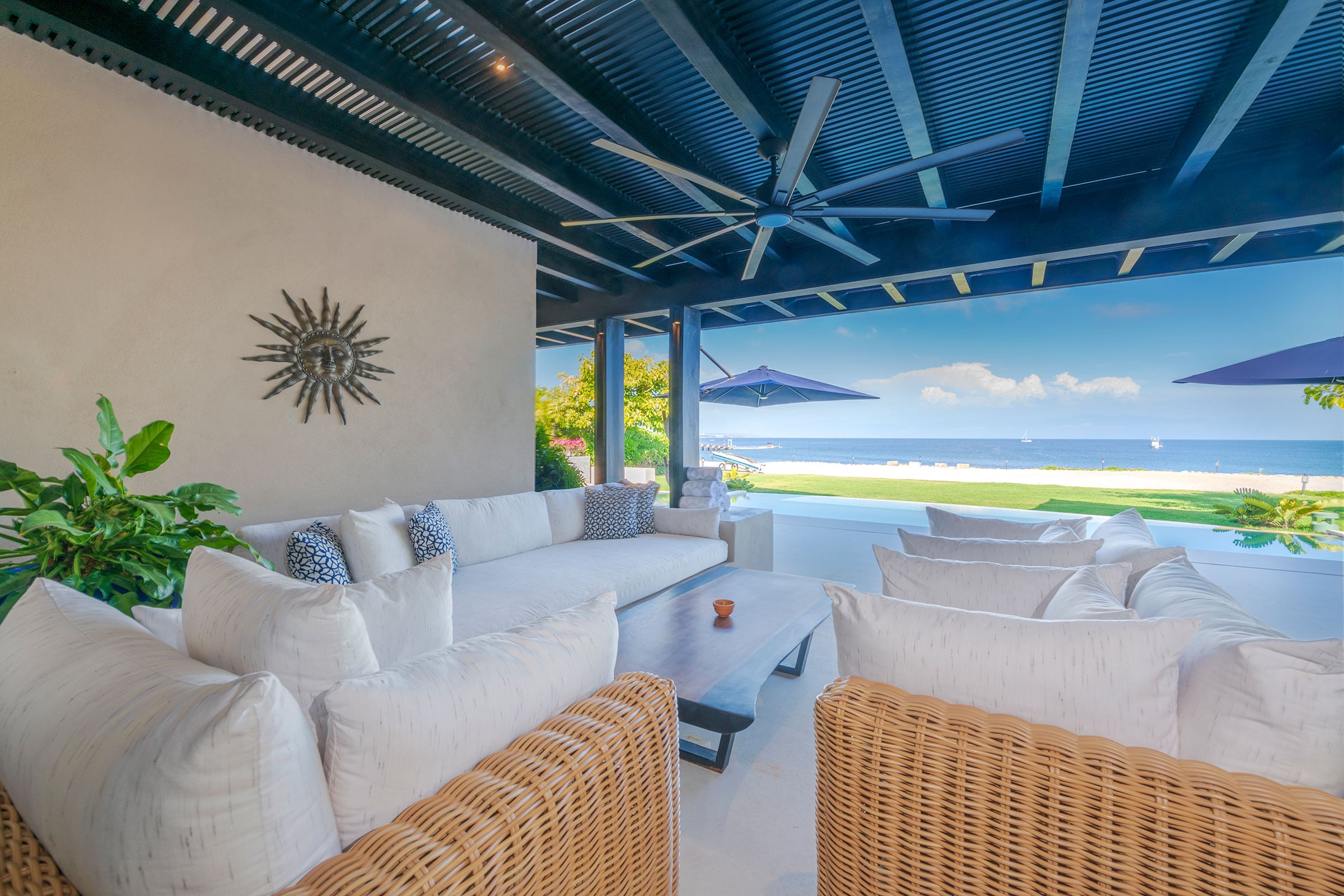 Villa Aurora covered terrace with sofas and a sunburst wall accent — Punta Mita Nayarit, Mexico