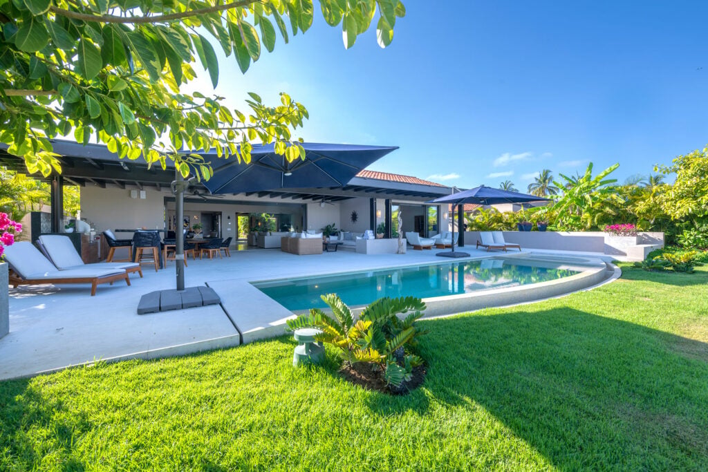 Villa Aurora villa exterior with a pool seen across the garden lawn — Punta Mita Nayarit, Mexico