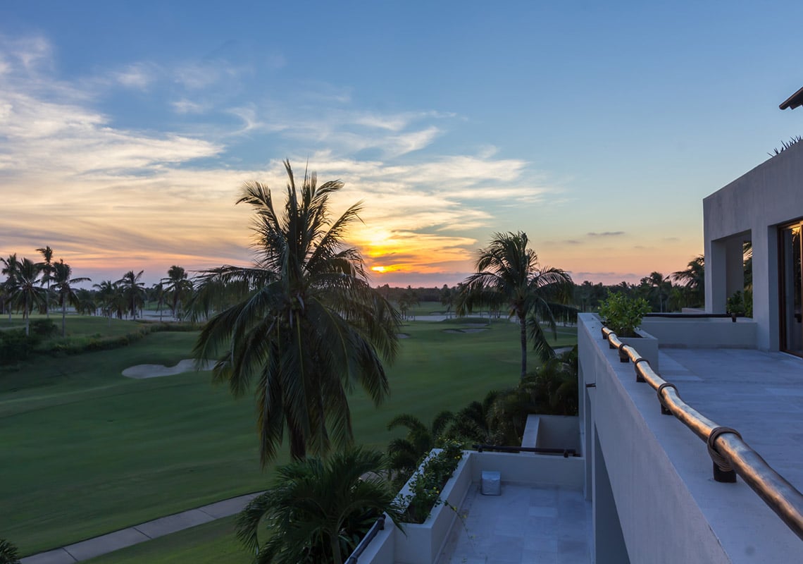 Condo Terrazas B32 a palm silhouetted against the sunset over the fairway — Punta Mita, Mexico