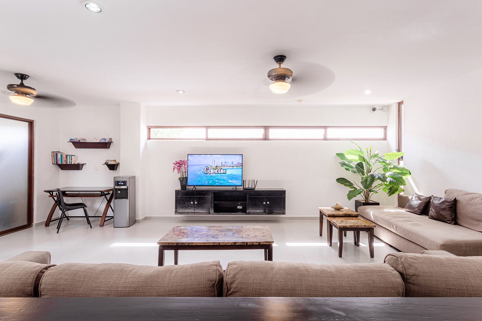 Villa Bellamar living room with a sectional sofa, TV on a cabinet and small desk — Akumal, Mexico
