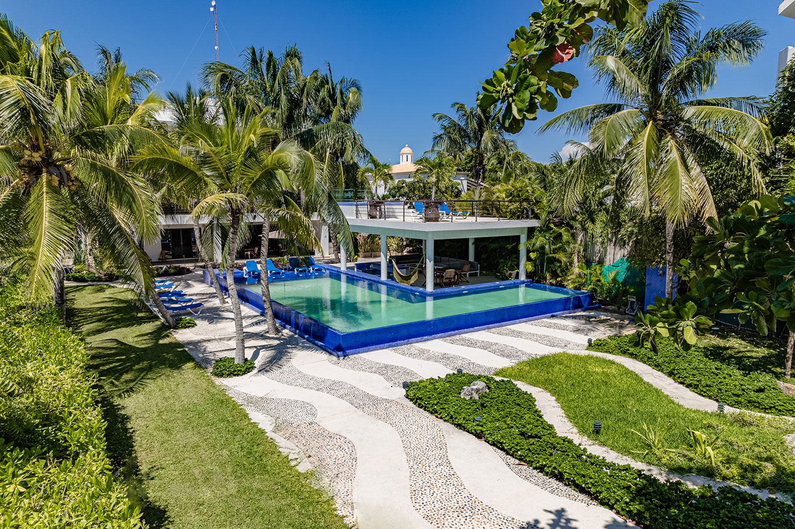 Villa Bellamar pool and palm garden beside a winding pebble path — Akumal, Mexico