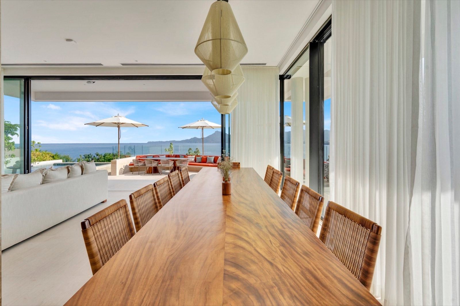 Casa Dinamita long dining table with woven chairs facing the sea and hills — Punta Mita Nayarit, Mexico