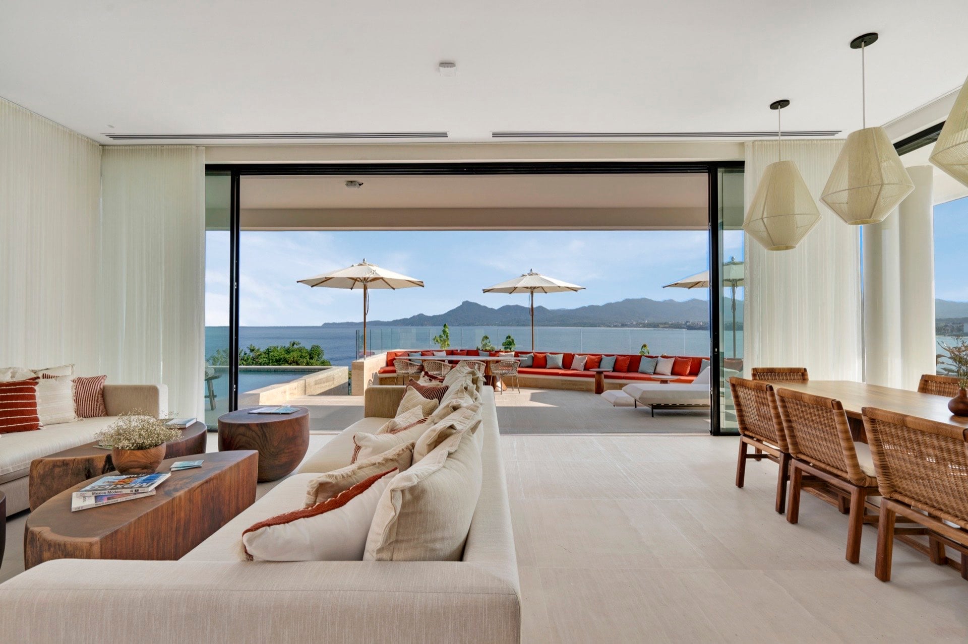Casa Dinamita living room opening to red-cushioned terrace seating and the sea — Punta Mita Nayarit, Mexico